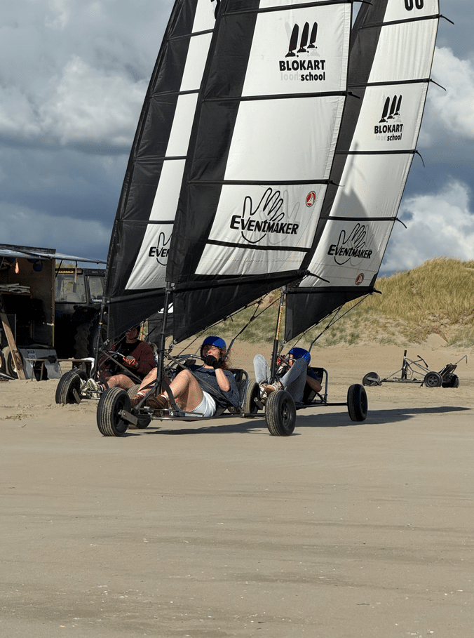 Vrijgezellenfeest blokarten met 6,5 m zeilen Groep vrienden blokartend tijdens een vrijgezellenfeest met unieke 6,5 meter zeilen op het strand van IJmuiden