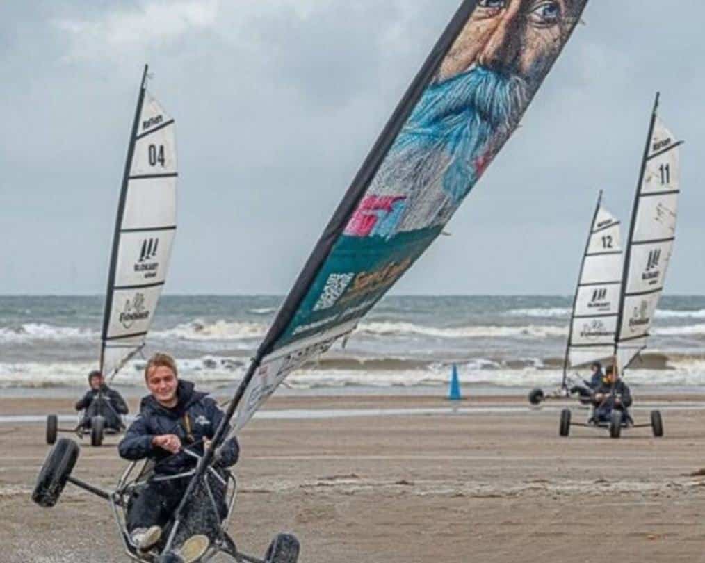 Man rijdt op 2 wielen met 6,5m zeil tijdens blokarten IJmuiden op Kennemerstrand